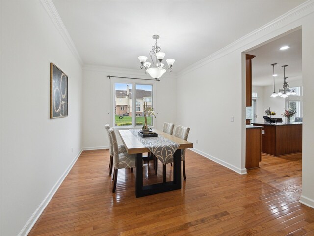 dining area with a chandelier, hardwood / wood-style floors, and baseboards