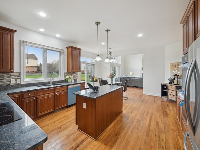 kitchen featuring a center island, tasteful backsplash, stainless steel appliances, and a sink