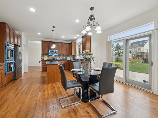 dining room featuring recessed lighting, light wood-style floors, and a notable chandelier