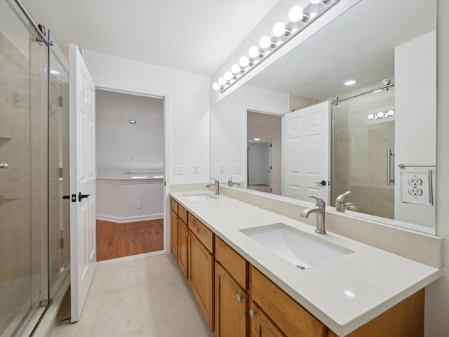 full bathroom with a sink, double vanity, and a stall shower