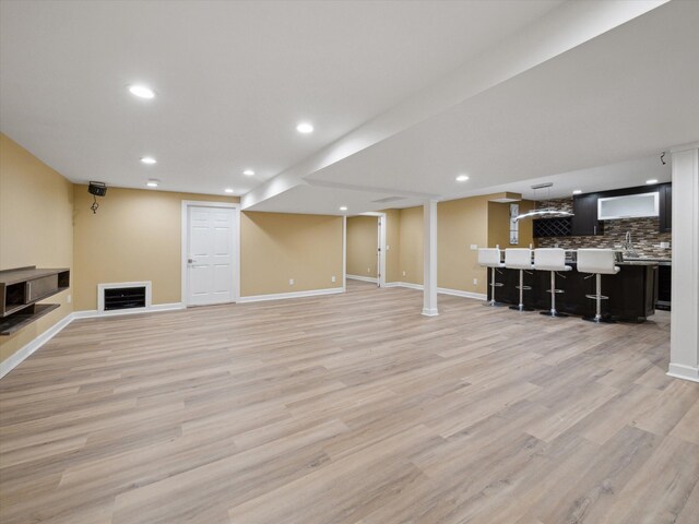 finished basement featuring recessed lighting, light wood-style floors, and baseboards