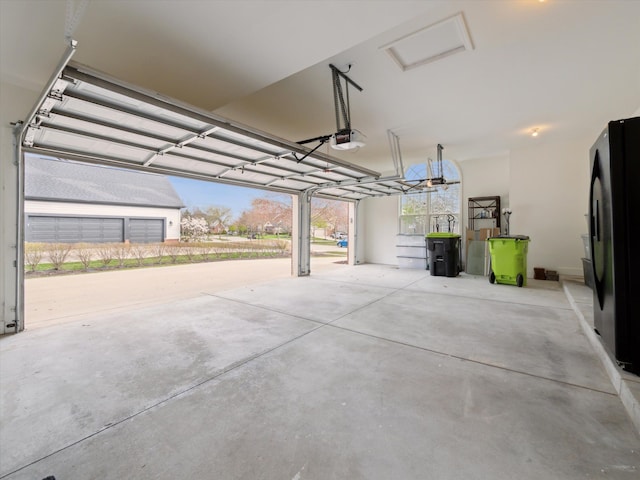 garage with a garage door opener and freestanding refrigerator