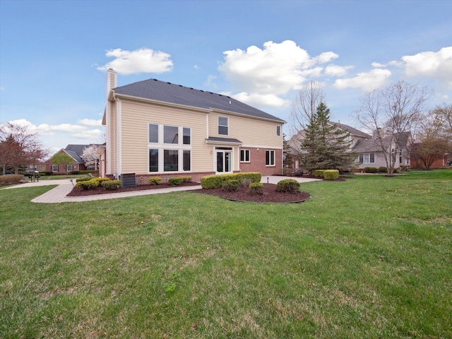 rear view of property with a lawn and a chimney