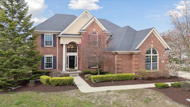 traditional-style home with brick siding and a shingled roof