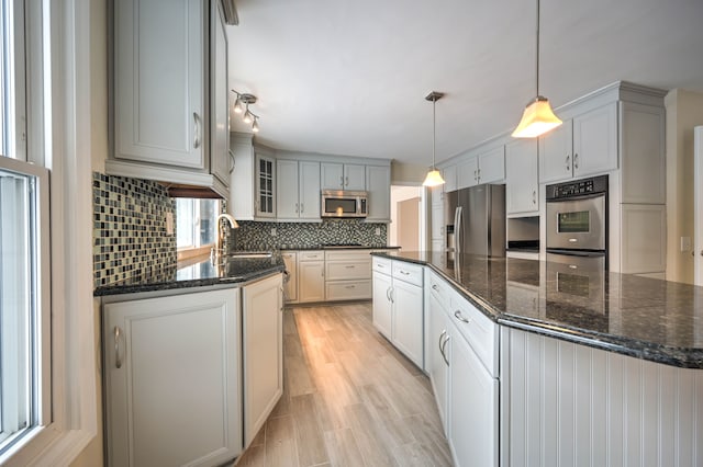 4238 Still Meadow Ln, West Bloomfield, MI 48323 - kitchen featuring stainless steel appliances, a sink, decorative backsplash, a kitchen island, and dark stone countertops