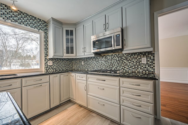 4238 Still Meadow Ln, West Bloomfield, MI 48323 - kitchen with appliances with stainless steel finishes, light wood-style floors, tasteful backsplash, and glass insert cabinets