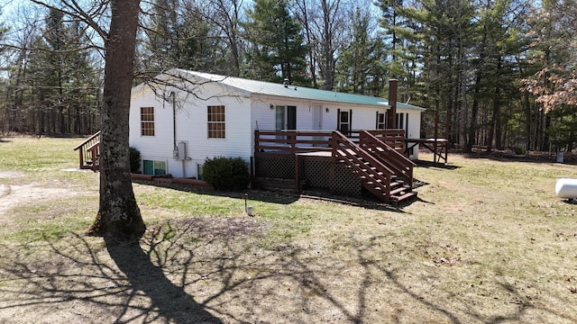 rear view of property with a lawn and a deck