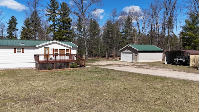 exterior space featuring a wooden deck, an outbuilding, a front yard, and metal roof