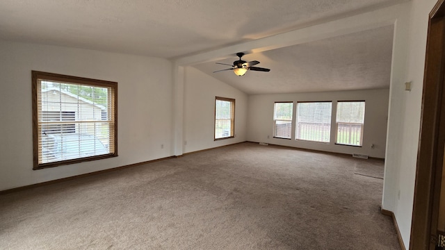 carpeted empty room with visible vents, vaulted ceiling with beams, baseboards, and a ceiling fan