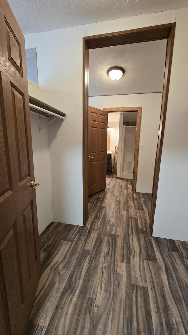 interior space with a textured ceiling and dark wood-style floors