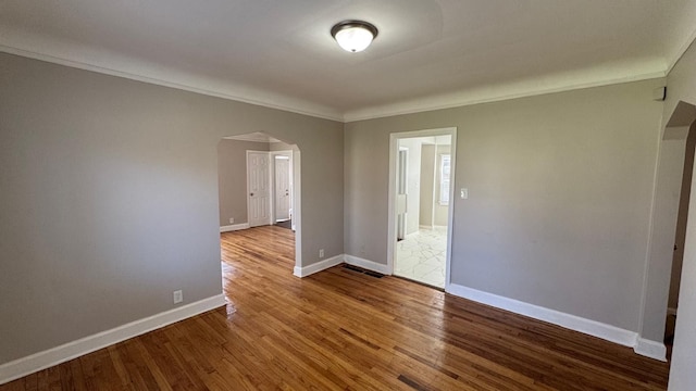 5051 Courville St, Detroit, MI 48224 - unfurnished room with baseboards, wood finished floors, arched walkways, and crown molding