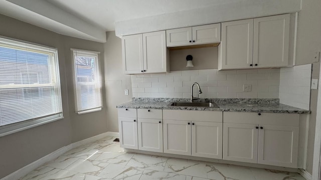 5051 Courville St, Detroit, MI 48224 - kitchen with marble finish floor, baseboards, white cabinetry, and a sink