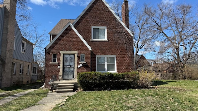5051 Courville St, Detroit, MI 48224 - tudor house with a chimney, brick siding, and a front yard