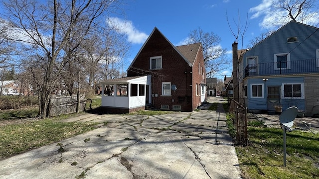 5051 Courville St, Detroit, MI 48224 - back of house featuring fence, a chimney, and a sunroom
