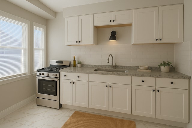 5051 Courville St, Detroit, MI 48224 - kitchen featuring marble finish floor, a sink, stainless steel range with gas cooktop, baseboards, and white cabinetry