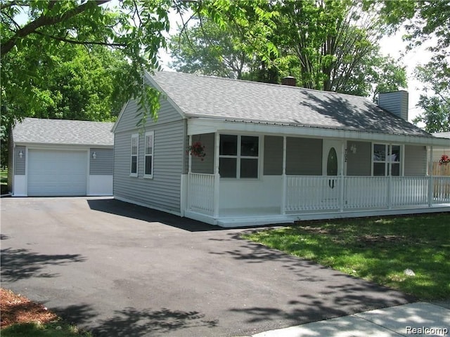 702 Oda St, Davison, MI 48423 - view of front facade featuring asphalt driveway, a chimney, an outdoor structure, roof with shingles, and a porch