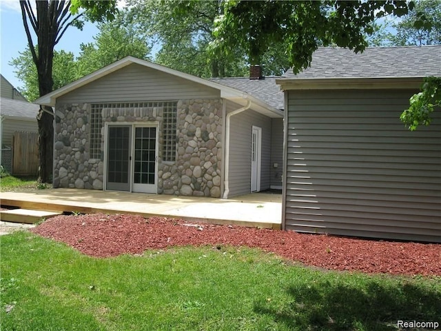 702 Oda St, Davison, MI 48423 - rear view of house featuring a patio, roof with shingles, and stone siding