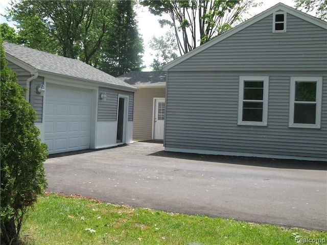 702 Oda St, Davison, MI 48423 - view of home's exterior with asphalt driveway, an outbuilding, and a shingled roof