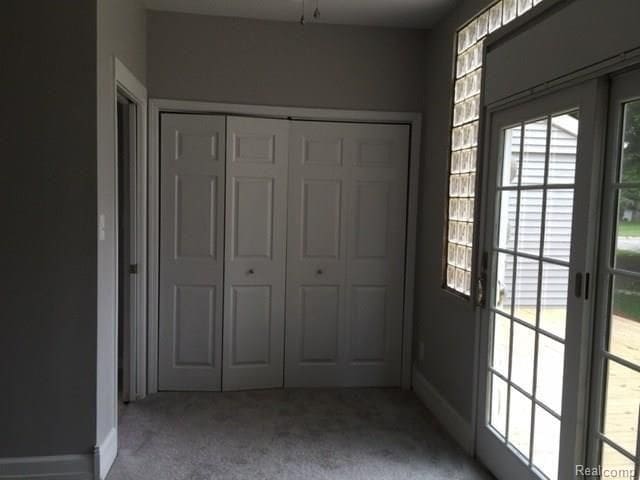 702 Oda St, Davison, MI 48423 - unfurnished bedroom featuring light carpet, a closet, and baseboards
