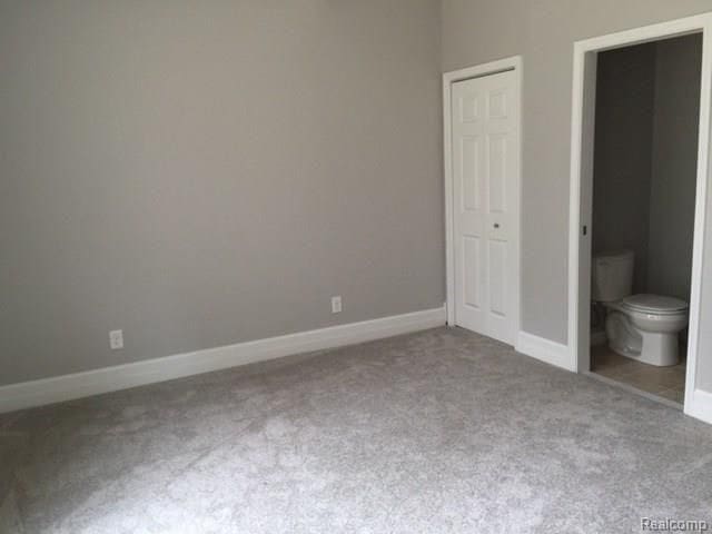 702 Oda St, Davison, MI 48423 - unfurnished bedroom featuring carpet flooring, baseboards, and ensuite bath
