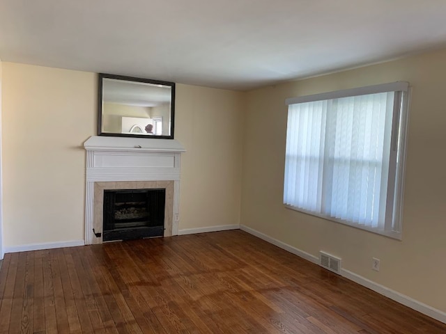 702 Oda St, Davison, MI 48423 - unfurnished living room with wood finished floors, a tiled fireplace, and baseboards