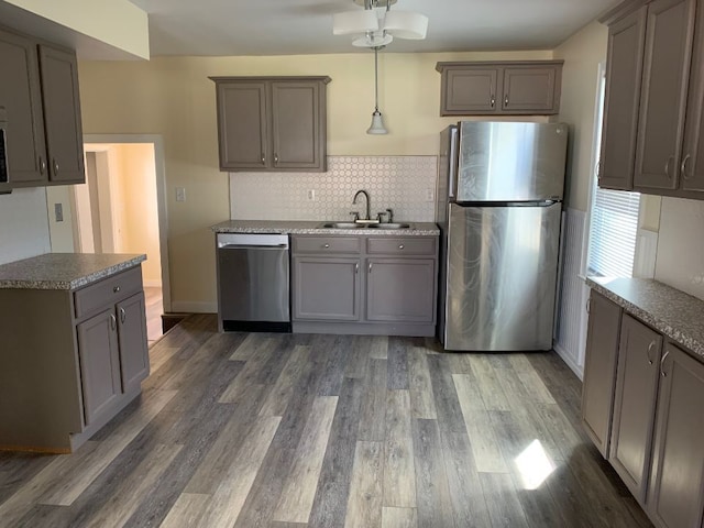 702 Oda St, Davison, MI 48423 - kitchen with stainless steel appliances, a sink, wood finished floors, gray cabinetry, and decorative light fixtures
