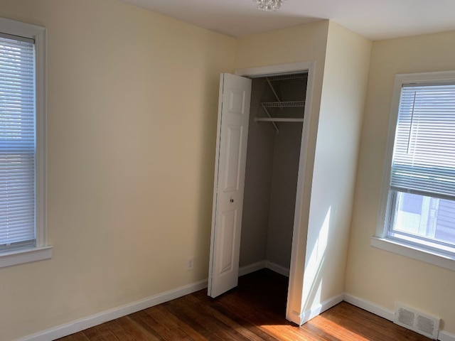 702 Oda St, Davison, MI 48423 - unfurnished bedroom featuring dark wood finished floors, a closet, and baseboards