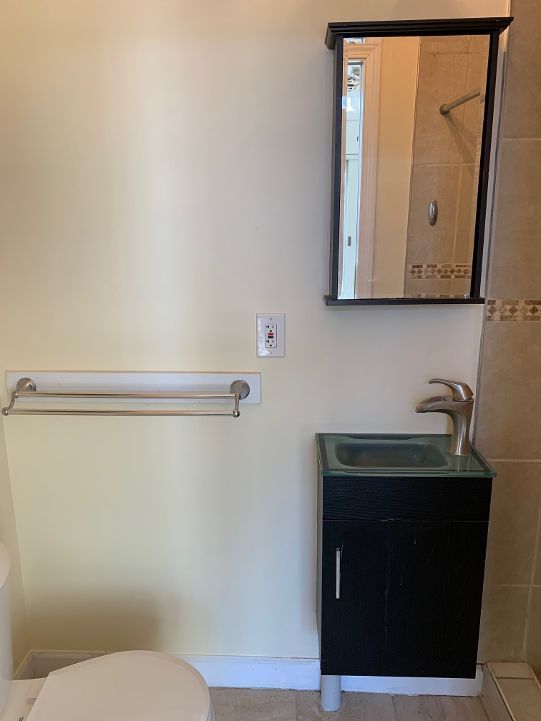 702 Oda St, Davison, MI 48423 - full bathroom featuring toilet, vanity, tiled shower, and baseboards