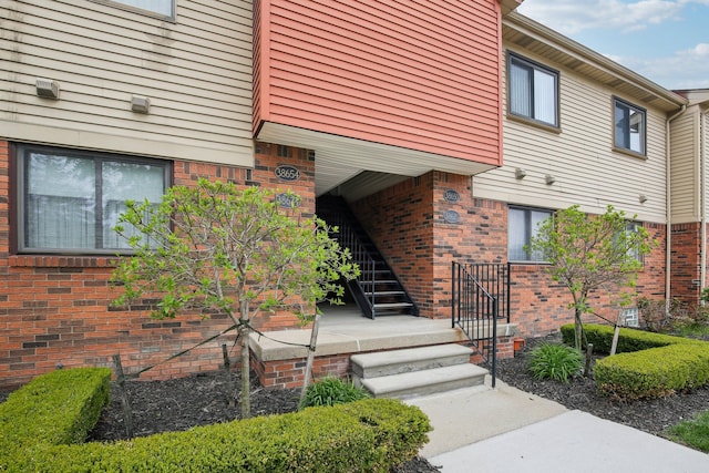 doorway to property featuring brick siding