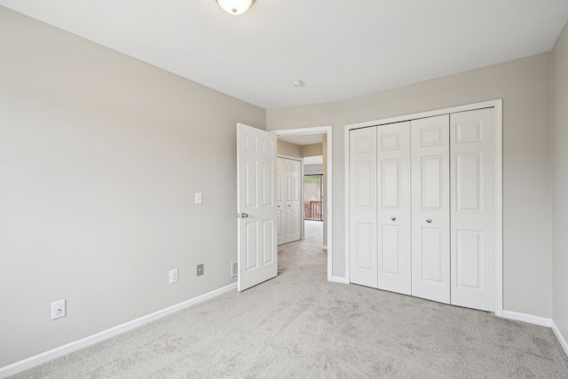 unfurnished bedroom featuring carpet flooring, baseboards, and a closet