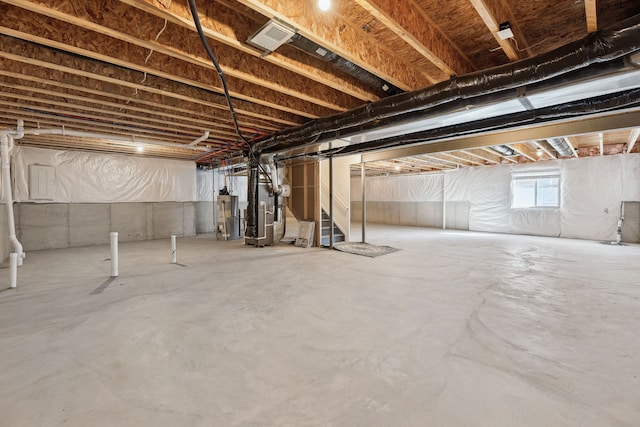 below grade area with water heater, stairs, and visible vents