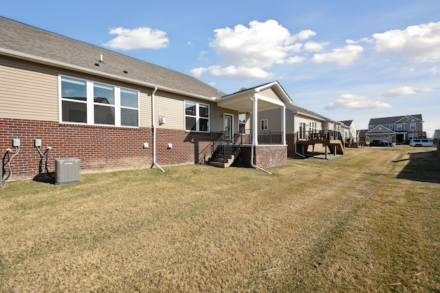view of property exterior featuring stairway, a lawn, a deck, cooling unit, and brick siding