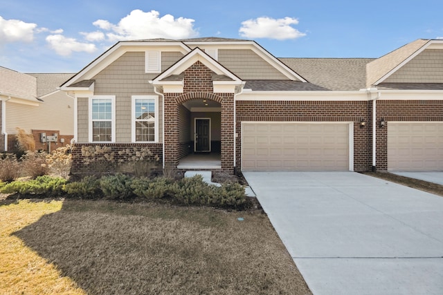 view of front of home with a garage, brick siding, a shingled roof, and concrete driveway