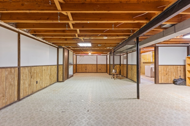 finished below grade area with washing machine and clothes dryer, wainscoting, and wood walls