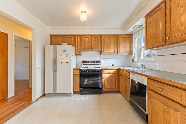kitchen with brown cabinets, dishwasher, freestanding refrigerator, and range with gas cooktop