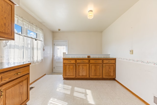 unfurnished room featuring light floors and baseboards