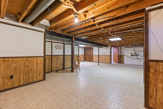 finished below grade area featuring wooden walls and wainscoting