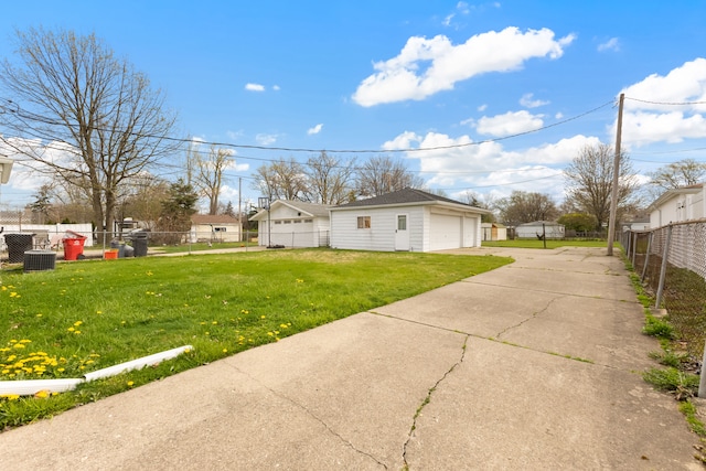 view of side of property featuring fence, an outdoor structure, a yard, and a garage