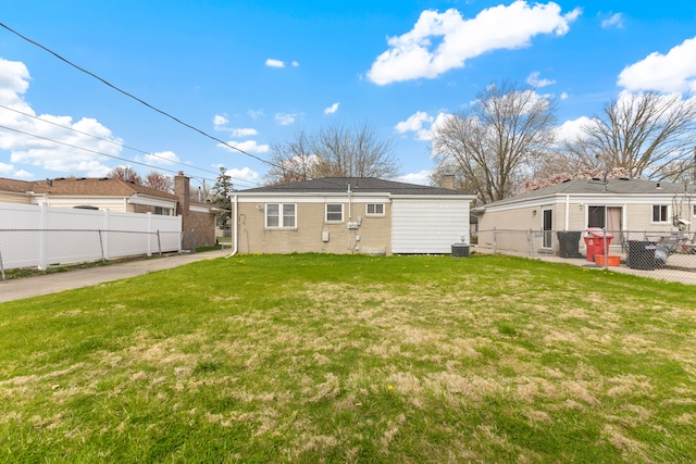 rear view of property with fence, a yard, and central air condition unit