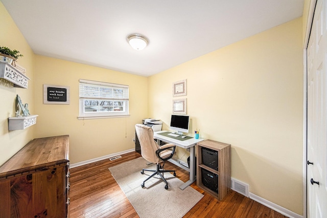 home office with baseboards, wood finished floors, and visible vents