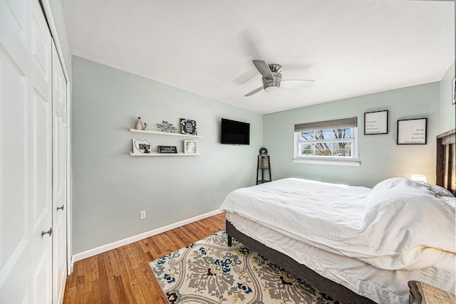 bedroom featuring baseboards, wood finished floors, and ceiling fan