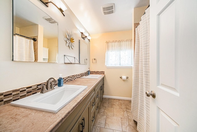 full bath featuring backsplash, double vanity, visible vents, and a sink