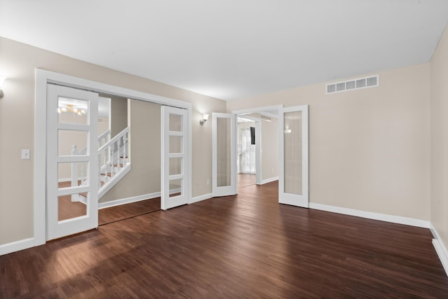 empty room featuring baseboards, french doors, wood finished floors, and visible vents