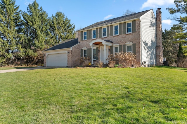 colonial home with an attached garage, driveway, a chimney, and a front yard