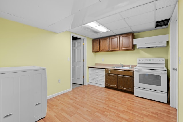 kitchen with white range with electric stovetop, extractor fan, a sink, light wood-style floors, and washer / clothes dryer