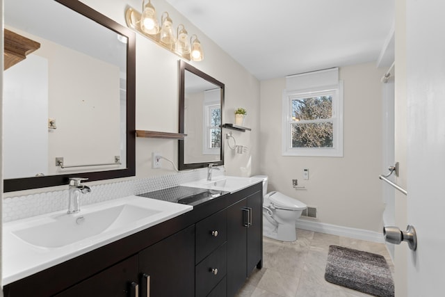 full bathroom featuring toilet, a sink, visible vents, and double vanity