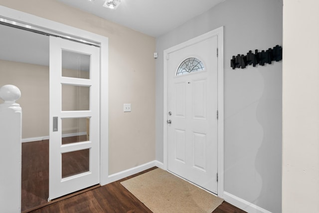 foyer entrance with baseboards and dark wood-style flooring