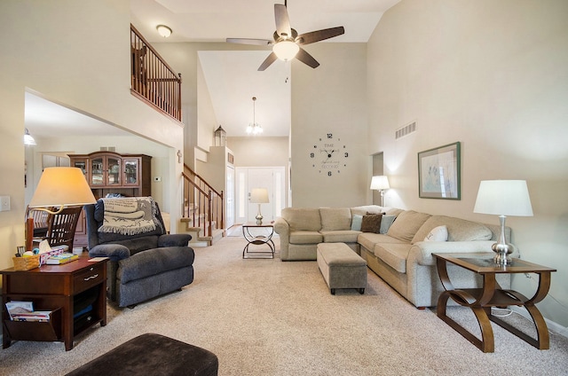 living room featuring stairway, high vaulted ceiling, carpet, and visible vents