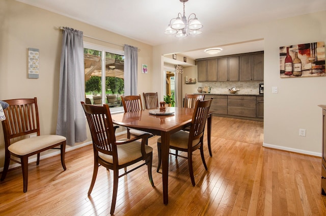 dining room featuring light wood-style floors, baseboards, and a chandelier