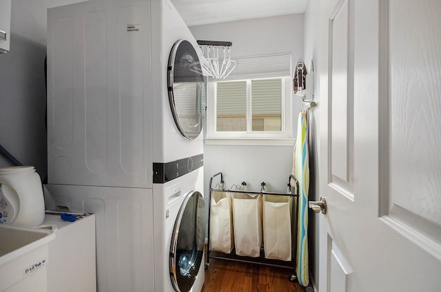 washroom featuring laundry area, dark wood-type flooring, and stacked washer / dryer